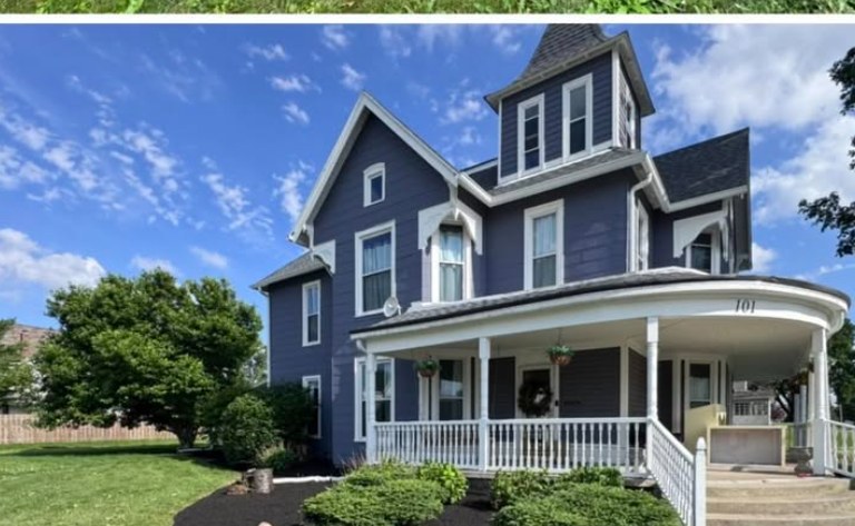 Restored Victorian home with redefined flower beds and fresh black mulch after a Jannings Property Solutions landscape transformation